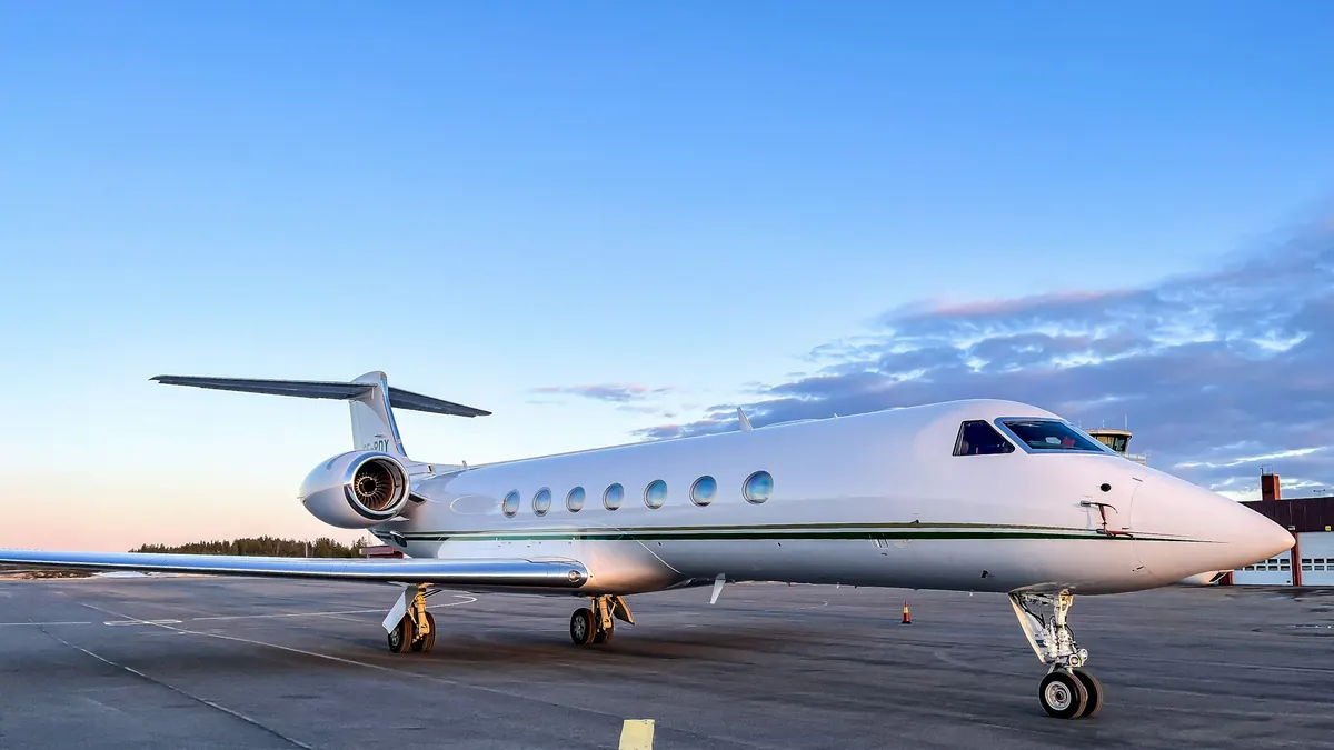 Gulfstream business jet parked on a ramp under a blue sky